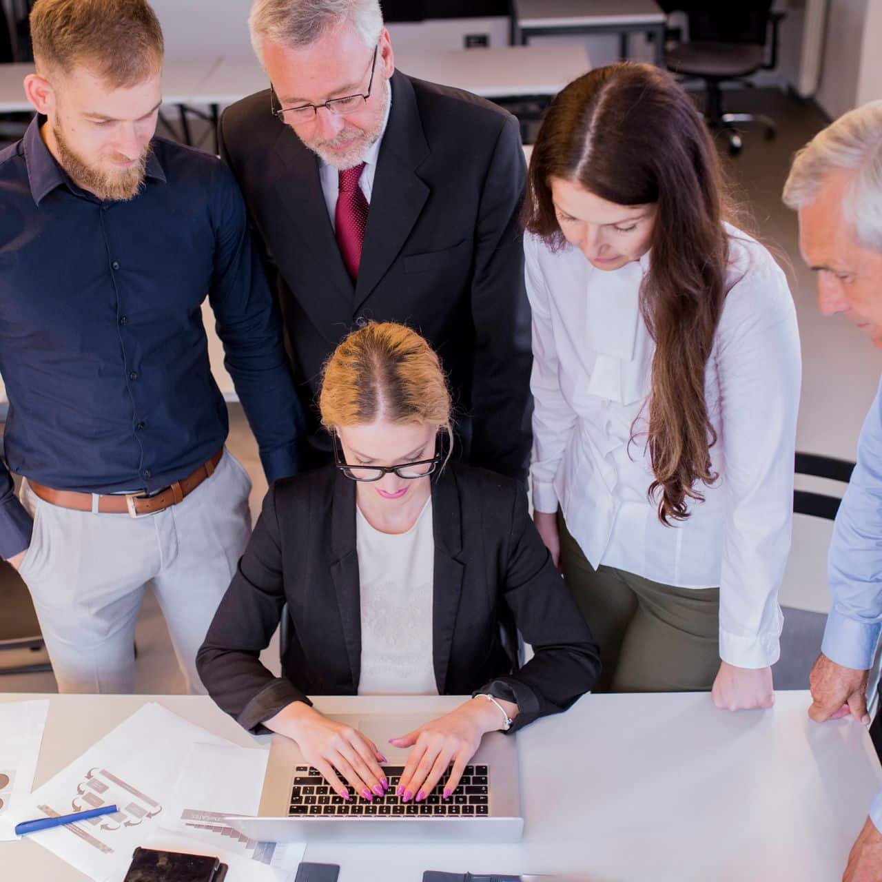 Team Of Professionals Collaborating On A Technology Project In An Office Setting.